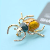 broche scarabée robe ocre fond bleu