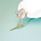 broche rose dorée fond vert