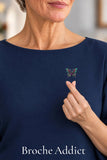 Broche Papillon Quantum Space portée sur une blouse bleu nuit avec un geste de cœur coréen